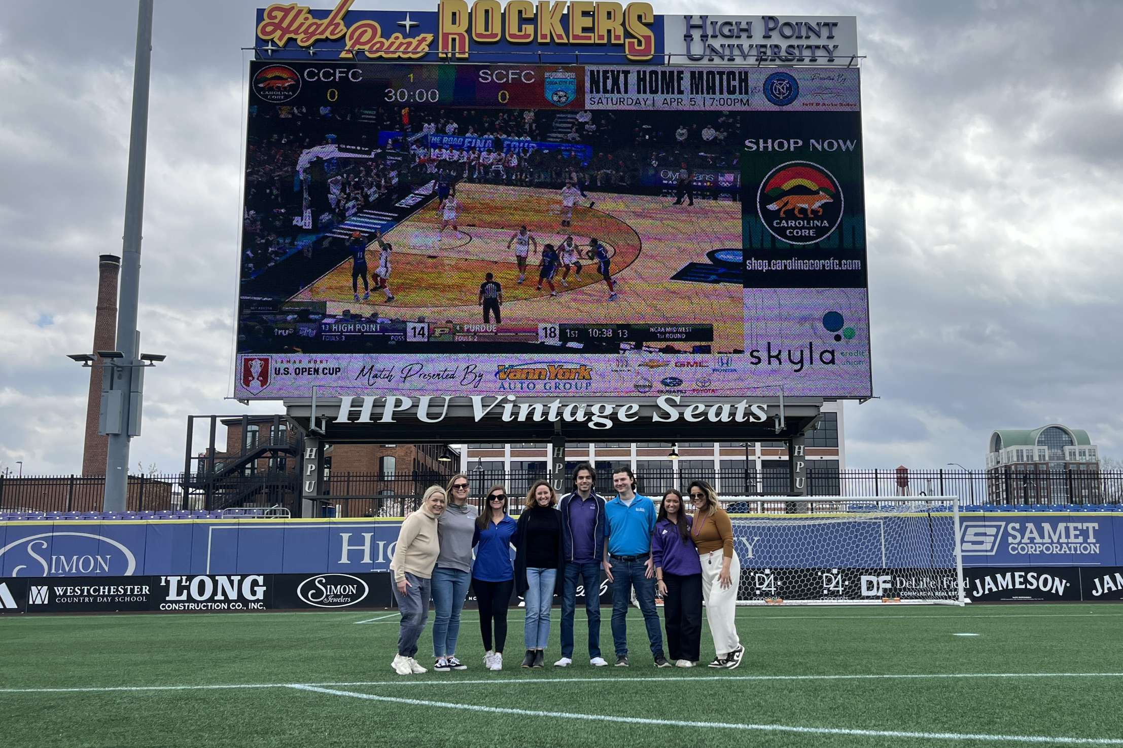 The Key Risk team watches the game from the local baseball field